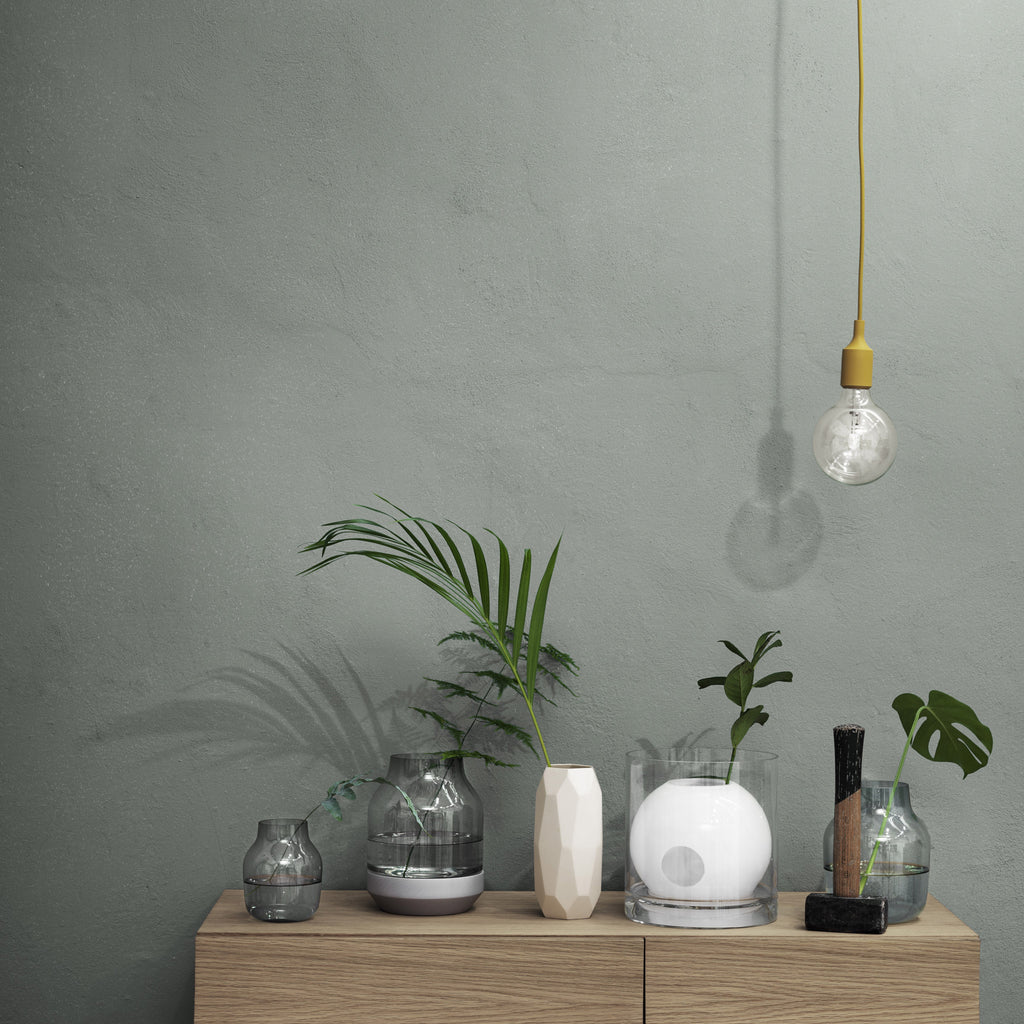 Muuto E27 Lampe in Gelb vor Pflanzenregal