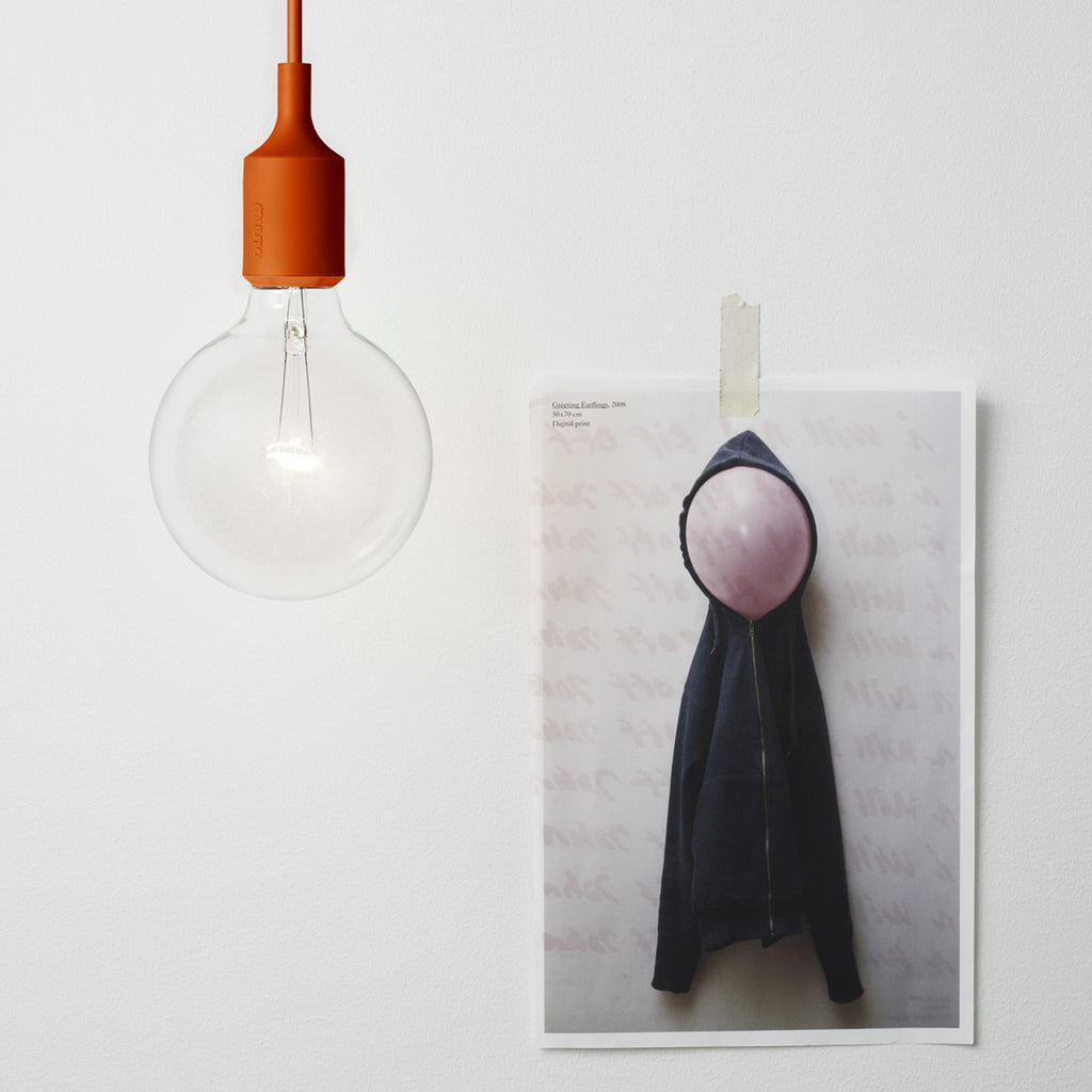 Muuto E27 Lampe in Orange vor Postkarte