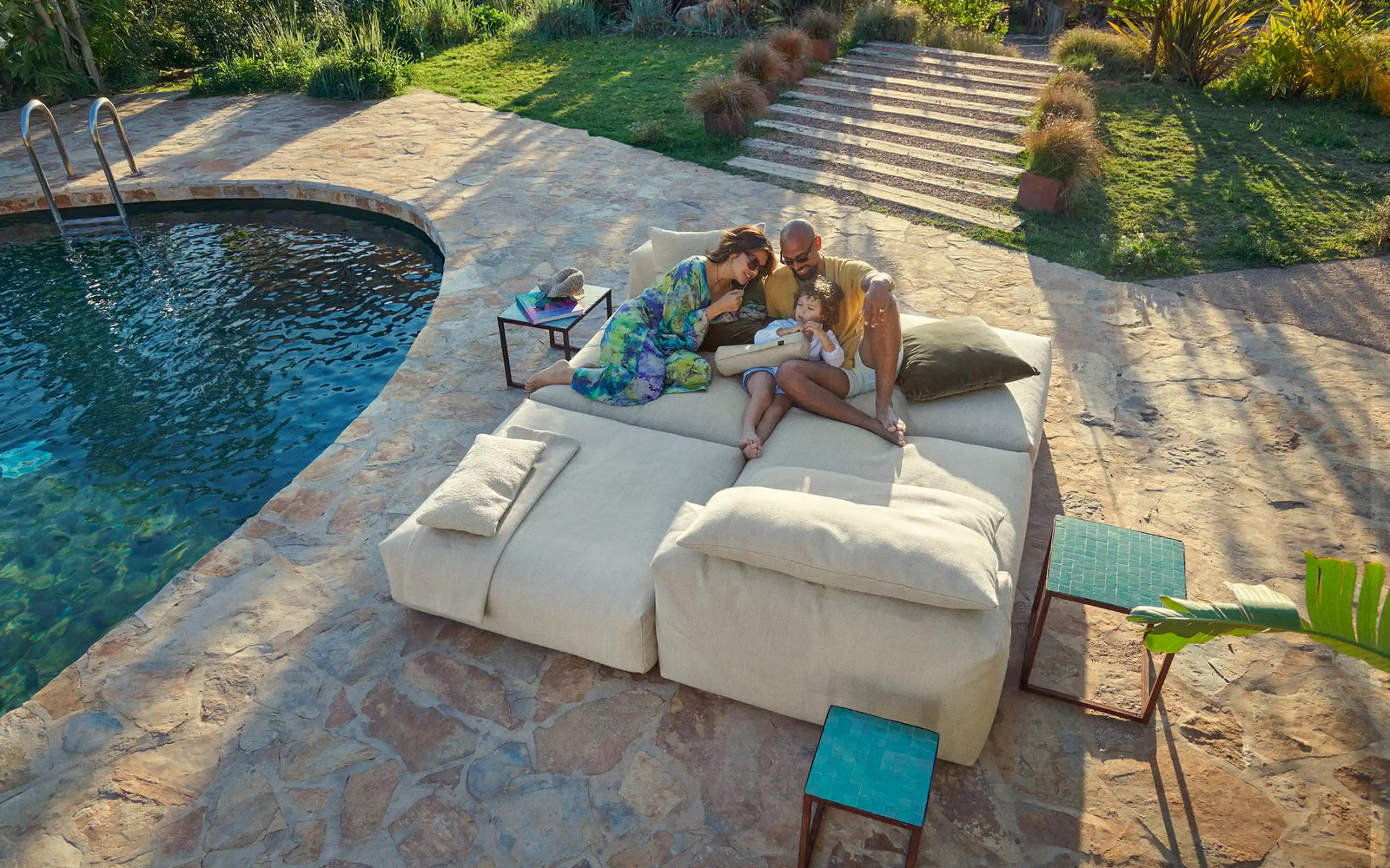 Familie auf vetsak Sofa neben Pool